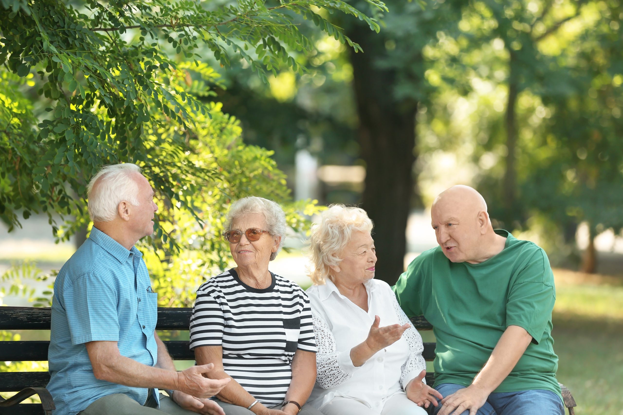 Older adults on a park bench in conversation